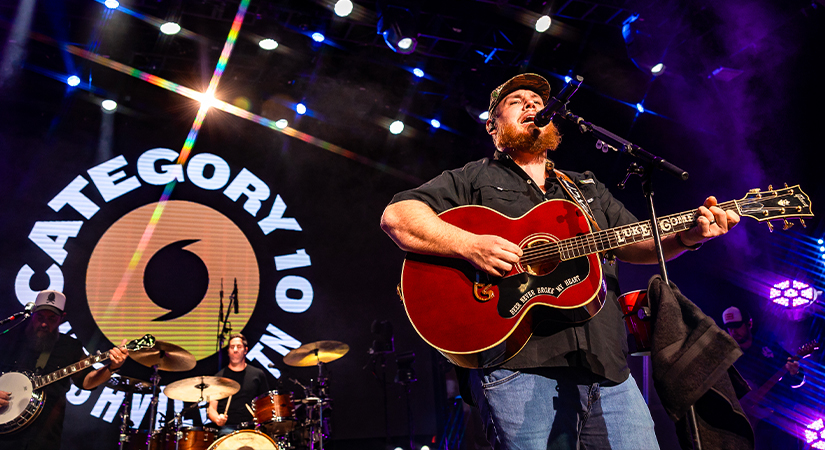 Luke Combs performs with guitar on stage at Category 10